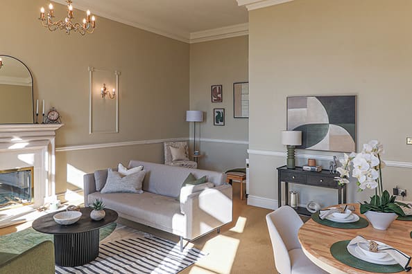 A stylish living room with a table and chairs, showcasing the design expertise of Penoyre House by Cymru Staging