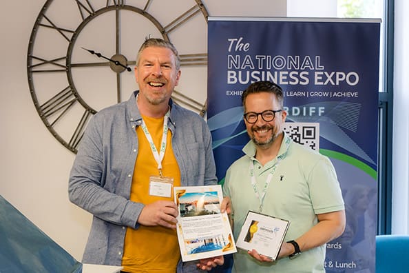 two men hold a certificate, celebrating their achievement at the Zokit networking meeting.
