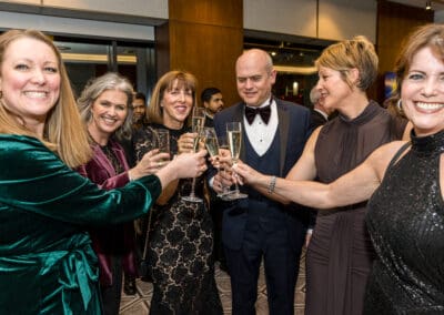 A group of people clinking glasses at an event